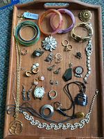 Overall view of entire jewelry lot on wooden tray