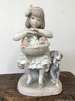 Front view of Lladro figurine showing girl with basket of flowers and dog