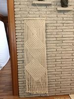 Full view of macramé hanging on wall showing overall design and scale