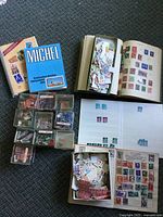 Overview of lot showing Michel book, spiral reference book, stock books, plastic boxes of stamps and loose stamps