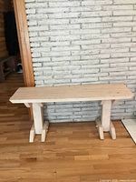 Full view of bench against brick wall