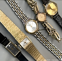 Close-up of all five watches overlapped showing case and band details