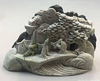 Front view showing full carved landscape scene and color contrast