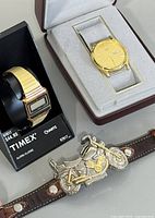 Citizen, Timex and motorcycle watches displayed with cases and stand