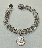 Full view of sterling silver bracelet with attached maple leaf charm