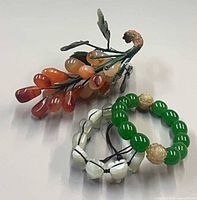 Overall lot view showing grape cluster and two bracelets