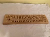 Top view of wooden cribbage board showing full scoring track