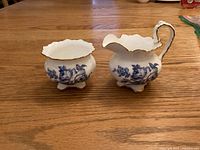 Front view of Aynsley creamer and sugar showing pattern and form