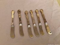 All six butter spreaders aligned showing fronts