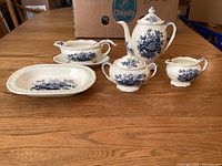 Entire set on table showing gravy boat with underplate, oval bowl, teapot, sugar and creamer