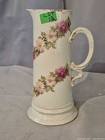 Full view of porcelain pitcher showing floral design and handle