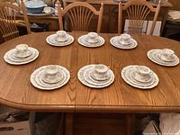 Full view of 8 complete place settings laid out on table