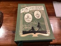 Front cover of green cloth-bound book with illustrated gilt design