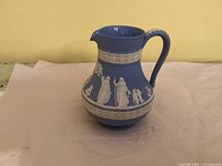 Left profile of Wedgwood blue Jasperware jug showing classical relief and handle
