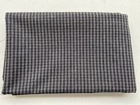 Folded length of black and grey check wool fabric