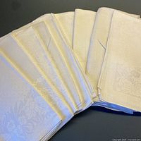 Stack and fan of 10 ivory damask linen napkins