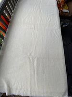 Full length view of cream wool crepe fabric laid out showing approximate yardage