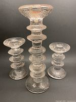 Front view of three clear textured glass Festivo candlesticks showing varying heights
