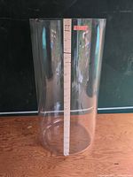 Full view of large clear glass cylinder standing upright