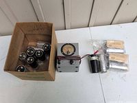 Box containing multiple loose Mallory capacitors plus view of voltmeter box, sealed capacitors and loose black capacitor