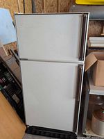 Front view of white top-freezer refrigerator showing two doors and handles