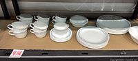 Full shelf view showing entire dinnerware set with cups, bowls and stacked plates