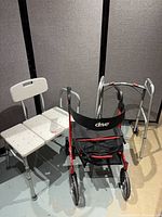 Rollator, folding walker and transfer bench grouped together showing overall condition and features