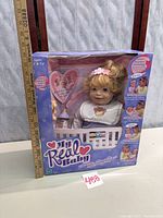 Front view of boxed Hasbro My Real Baby doll with ruler for scale