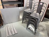 Table top, stacked chairs, detached legs visible