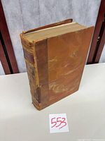 Oblique view of full leather book showing spine, boards, wear