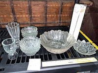 group shot of clear pressed glass bowls, vase, goblet and boxed item