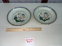 Both matching porcelain wall plates with ruler for scale