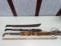 All three blades laid out with ruler for scale