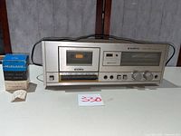 Front view of Sanyo RD-10 cassette deck and Midland 14-102 audio level control with box and insert