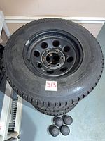 Stack of four tires on rims with lot id sticker visible