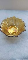 Top view of marigold carnival glass bowl showing scalloped rim and iridescent finish