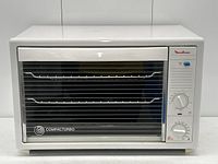 Front view showing entire Moulinex Compacturbo toaster oven with glass door and racks