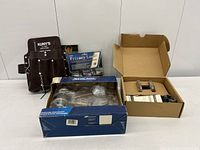 Group view showing Schlage lockset, privacy lock package, Kuny’s leather tool belt pouch, and open box of hardware