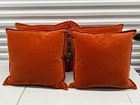 Front view of all four burnt orange velvet pillows