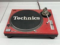 Full view of Technics SL-1200 MK2 turntable showing custom red finish and missing head shell