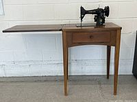 Full view cabinet with leaf extended and machine raised