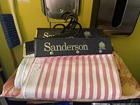 Two Sanderson hangers on table showing striped sample and second hanger.