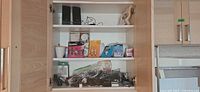 Cabinet shelves with speakers, camera, phones, chargers, light bulbs and cables