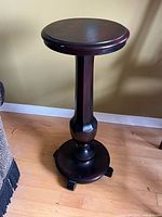 Full view of wooden pedestal plant stand showing top, column, base, overall design