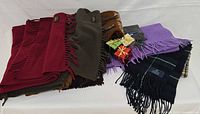 Stack of assorted solid and plaid lambswool scarves