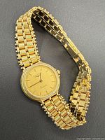 Full view of watch showing case and integrated bracelet on black background