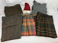 Five folded wool pants showing patterns and colors