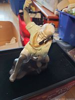 Front view of porcelain elder figure on rock base