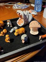 Tray showing grey ceramic open-mouth hippo and assorted small hippos