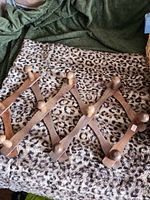 Front view of expanded wooden accordion coat rack with 10 pegs